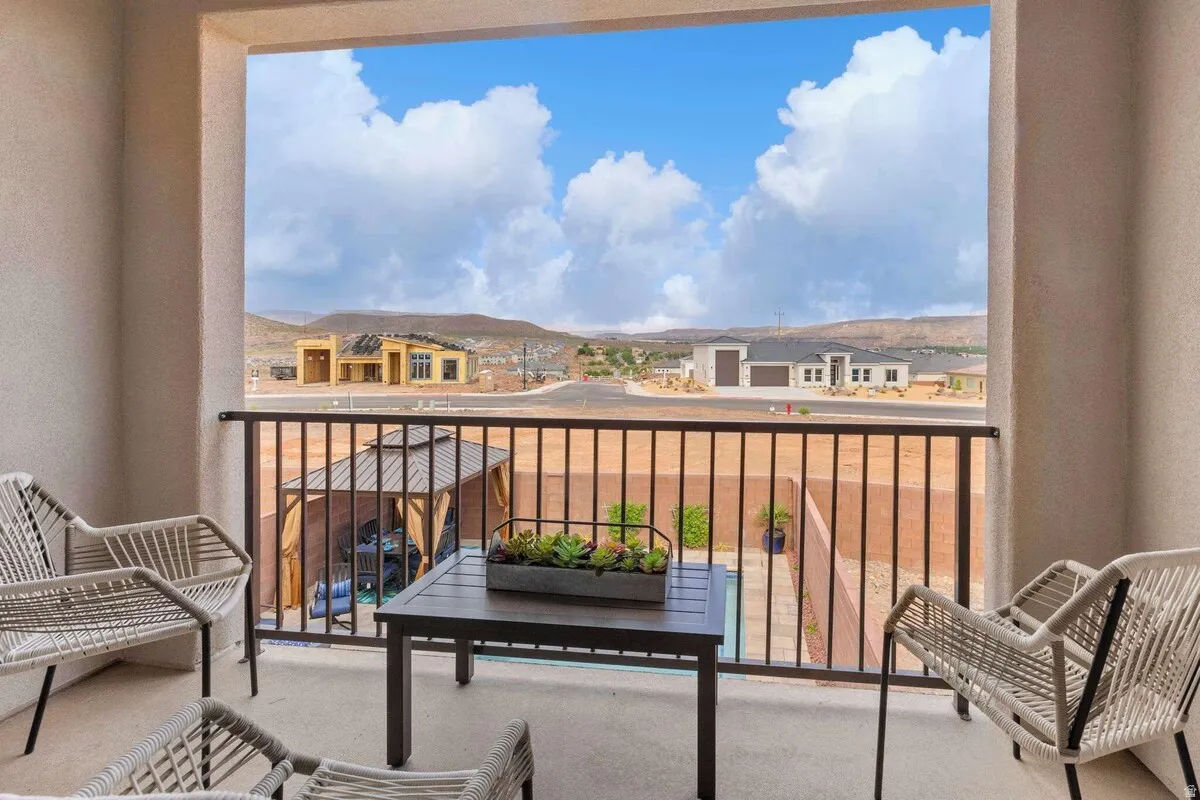 Outdoor balcony featuring a concrete surface, a black metal railing, and a desert landscape backdrop