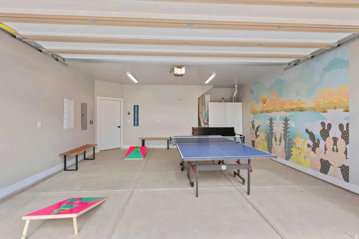 Spacious garage featuring a decorative mural wall, concrete flooring, and recessed lighting