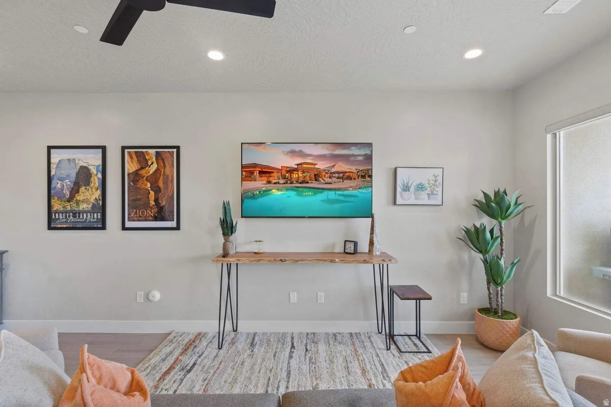 Light-toned walls with recessed ceiling lights and a black ceiling fan