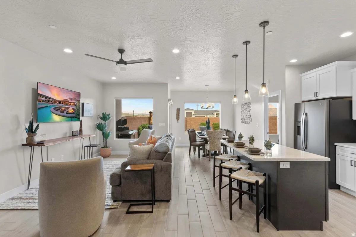 Open-concept living space featuring wood-finish flooring, recessed lighting, and a modern ceiling fan