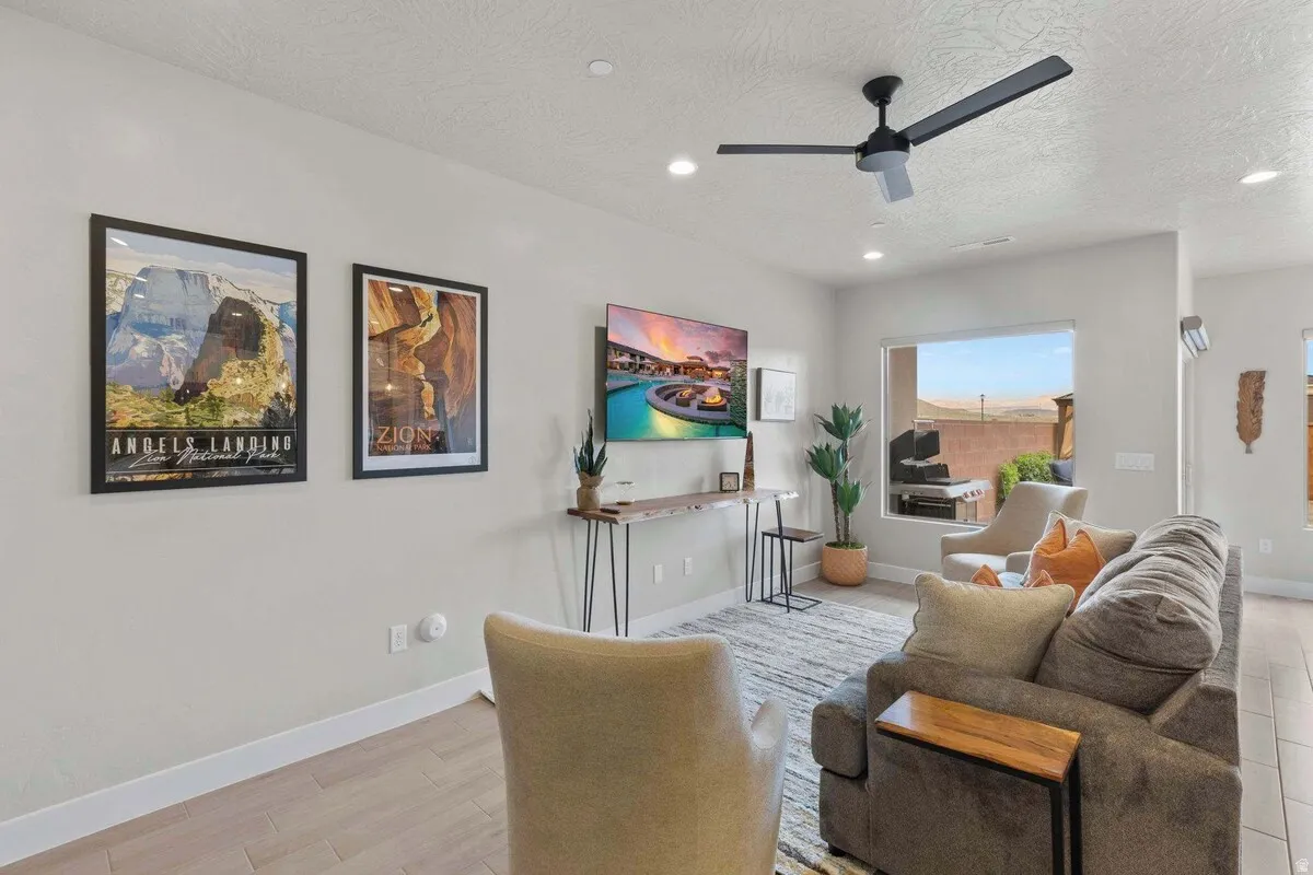 Open-concept living space featuring wood-finish flooring, recessed lighting, and a contemporary ceiling fan