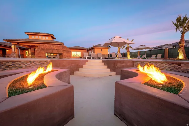 Outdoor entertainment area featuring two integrated curved fire features with decorative landscaping