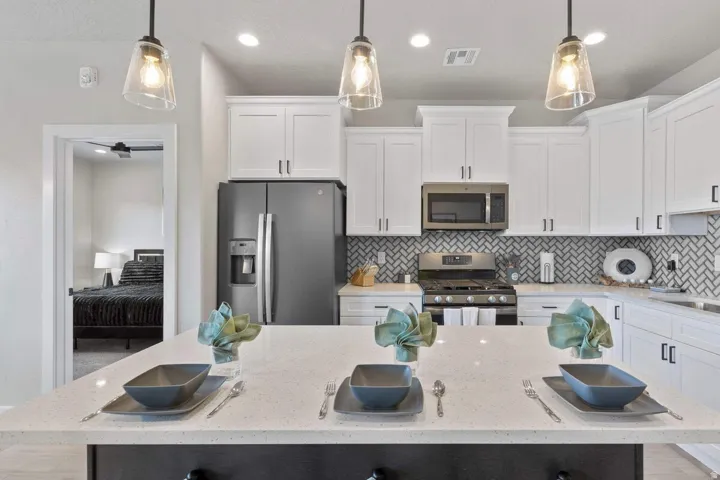 Kitchen island with a light-toned countertop, complemented by three pendant lights