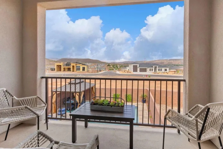 Outdoor balcony featuring a concrete surface, a black metal railing, and a desert landscape backdrop
