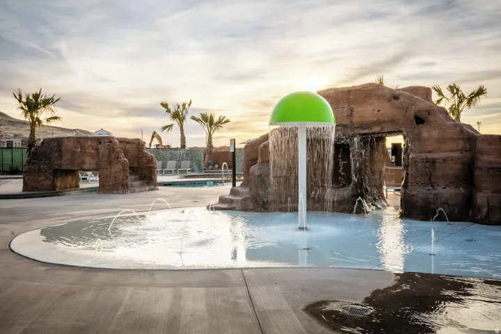 Splash pad with multiple water features, including a mushroom-style fountain and ground-level jets