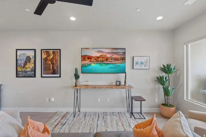 Light-toned walls with recessed ceiling lights and a black ceiling fan