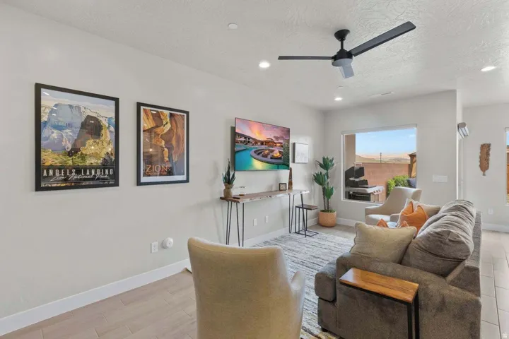 Open-concept living space featuring wood-finish flooring, recessed lighting, and a contemporary ceiling fan