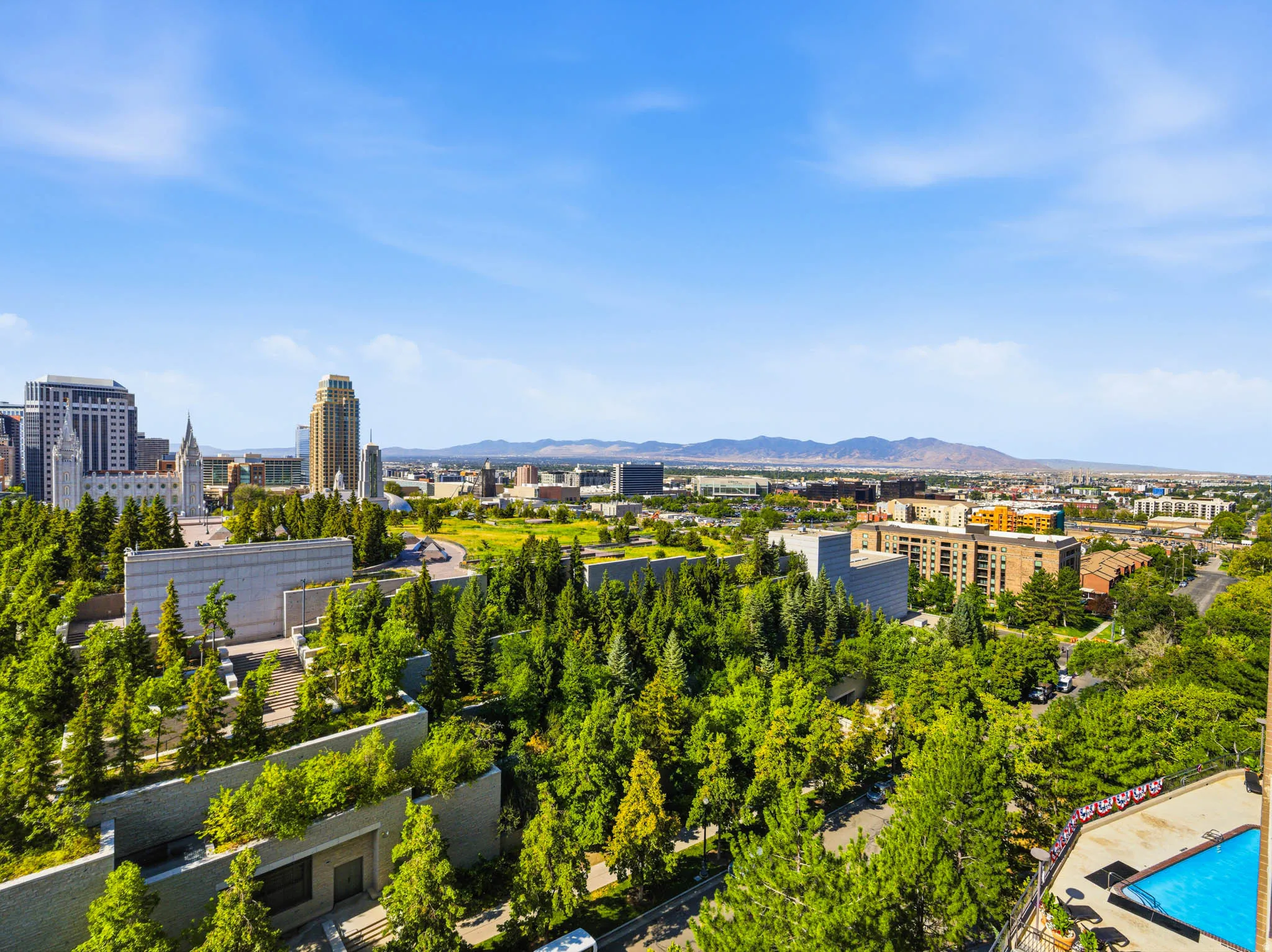 Panoramic cityscape with prominent downtown buildings and distant mountains