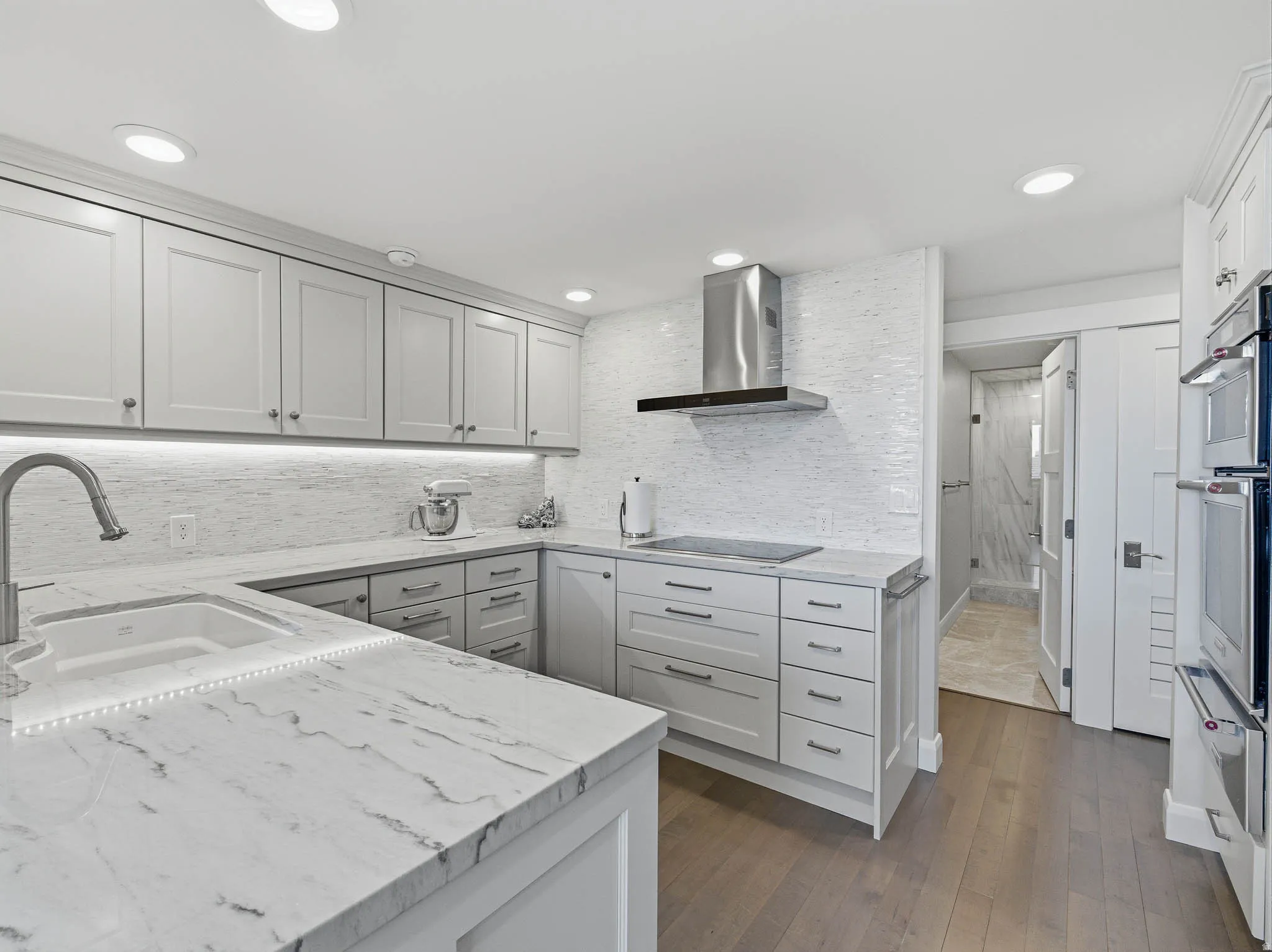 Contemporary kitchen featuring light-toned cabinetry and countertops with integrated sink
