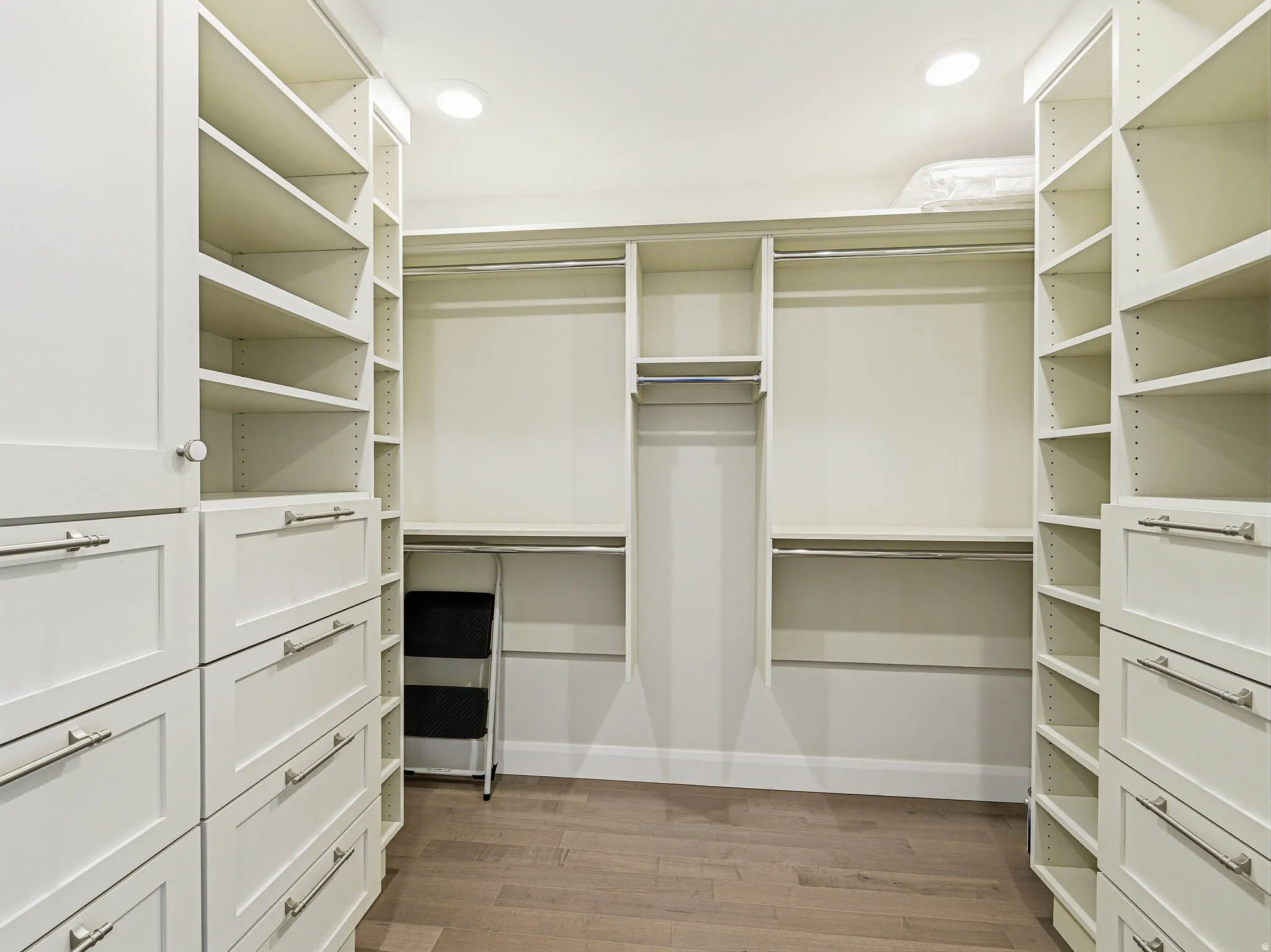 Custom closet system featuring extensive shelving and built-in drawers with brushed nickel hardware