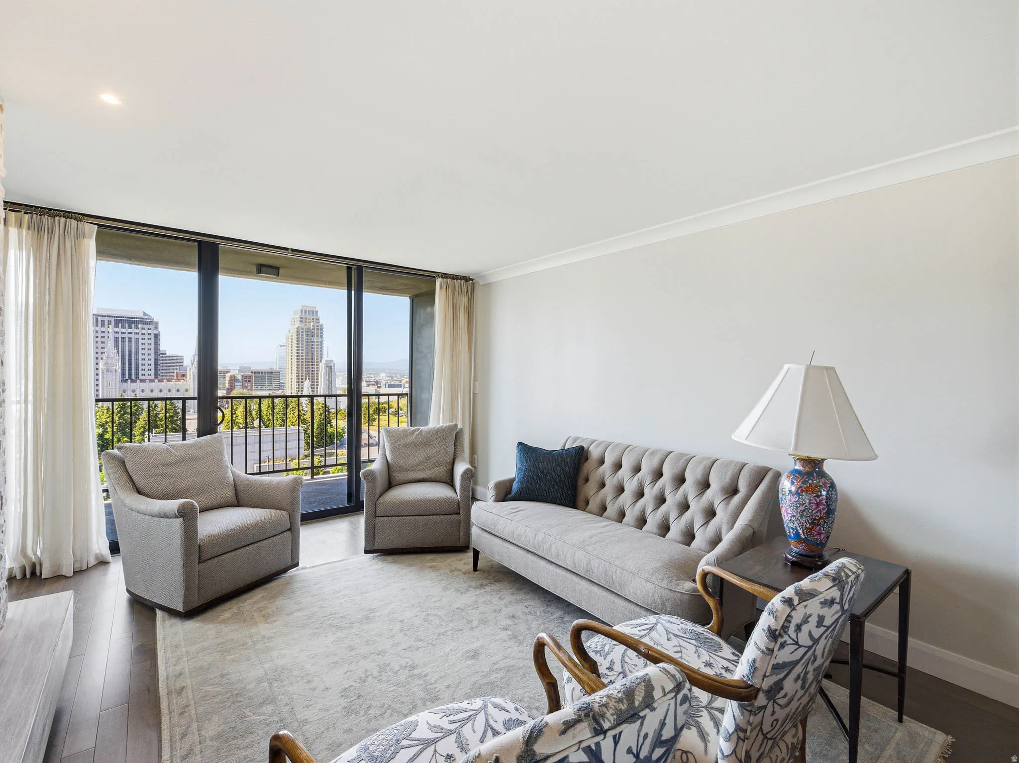 Living area featuring expansive floor-to-ceiling windows, wood-finish flooring, and crown molding