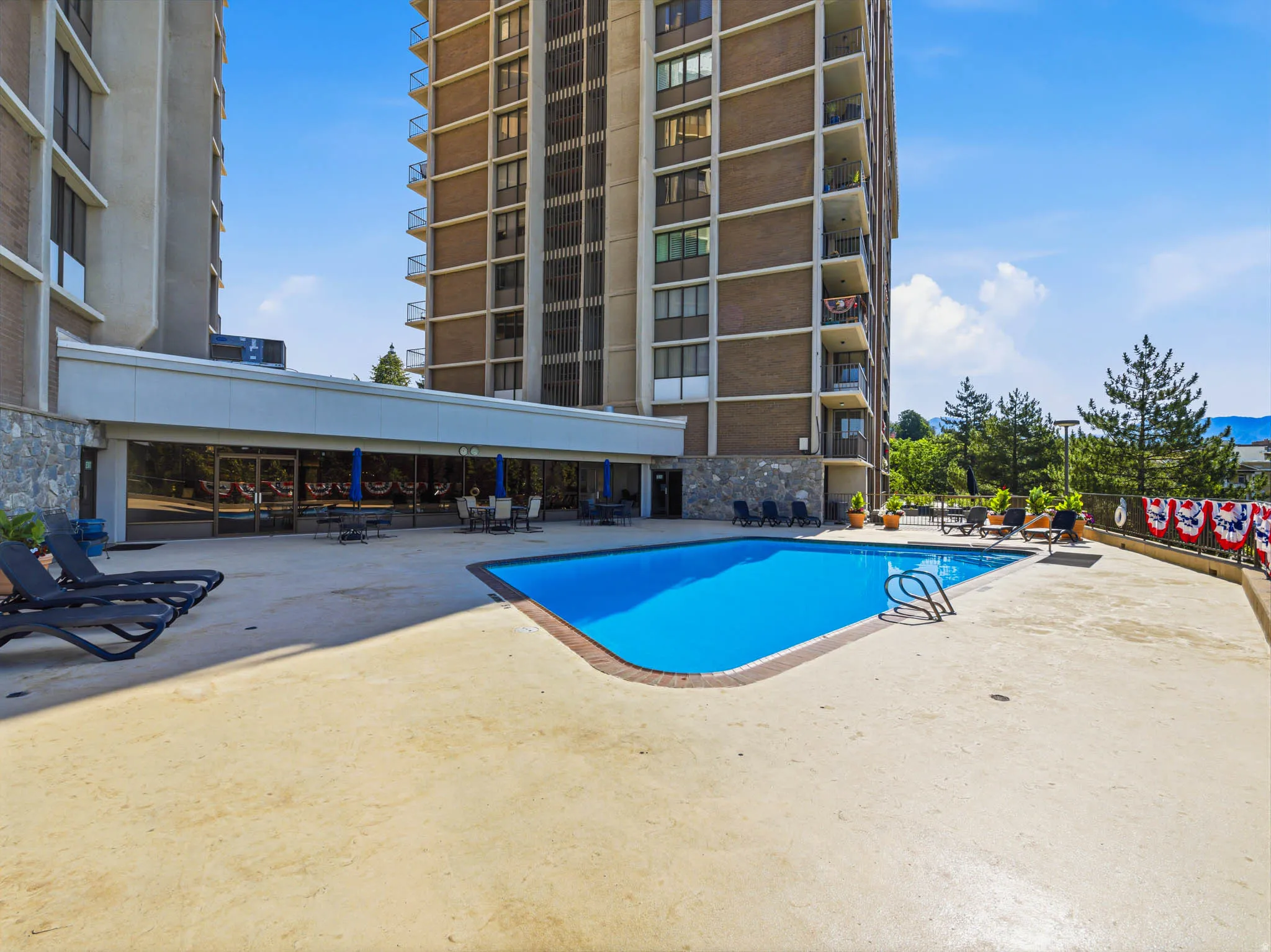 Outdoor swimming pool with integrated ladder, surrounded by concrete decking