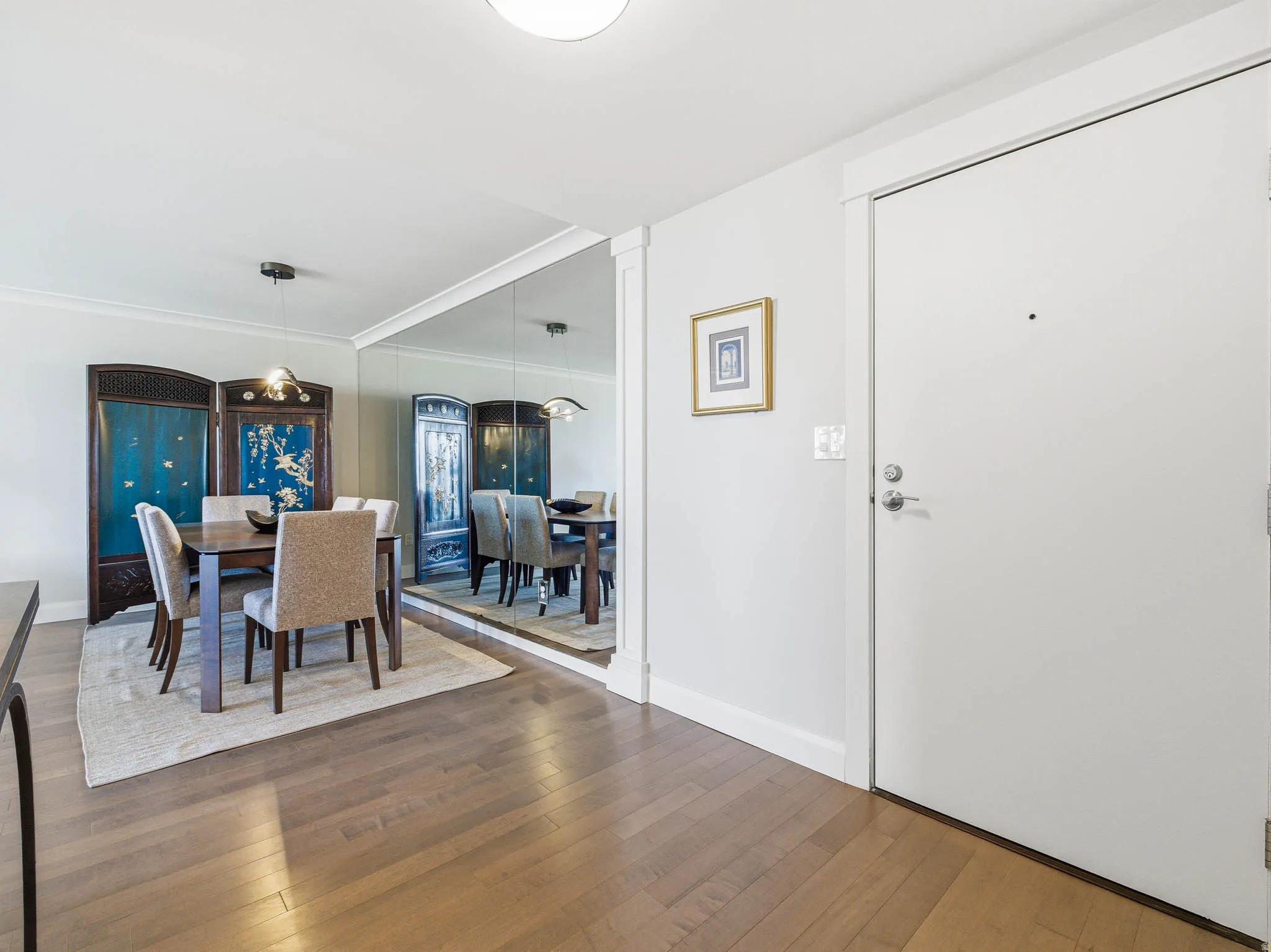 Light wood-finish flooring extending from the entryway into the dining area