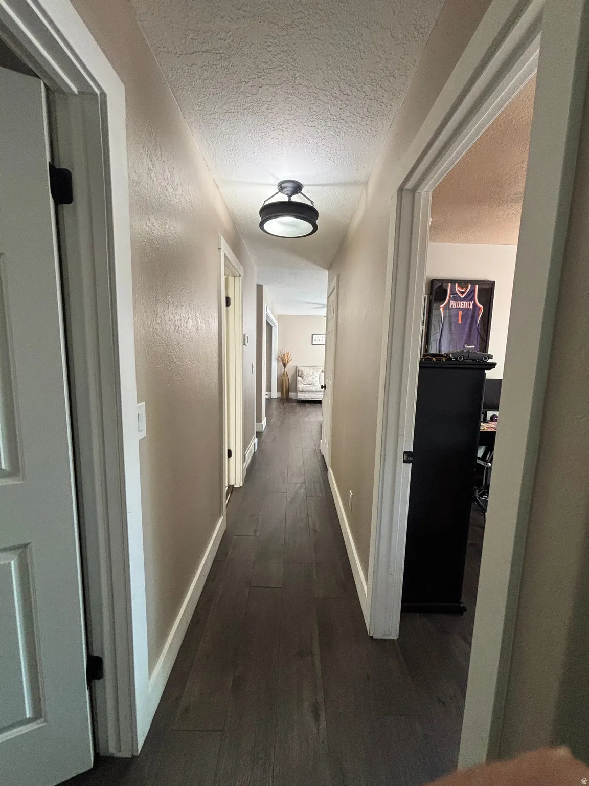 Hallway featuring dark wood-finish flooring and a contemporary semi-flush mount light fixture