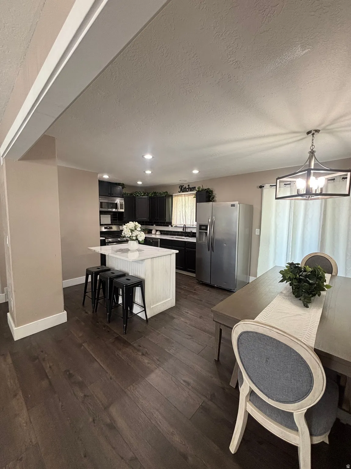 Kitchen featuring dark cabinetry, stainless steel appliances, and recessed lighting