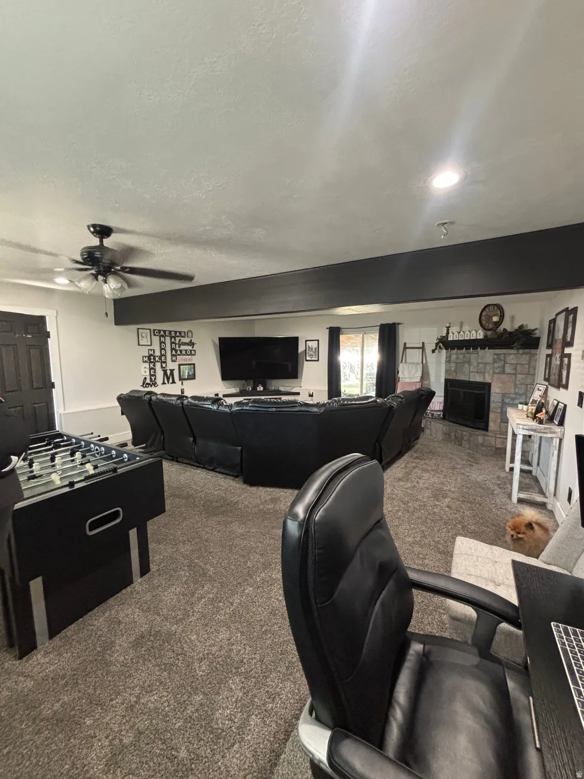 Spacious recreational room featuring recessed lighting, a ceiling fan, and a floor-to-ceiling stone fireplace