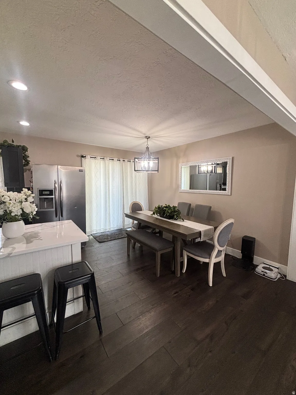 Open-concept living space featuring wood-finish flooring, recessed lighting, and a contemporary chandelier