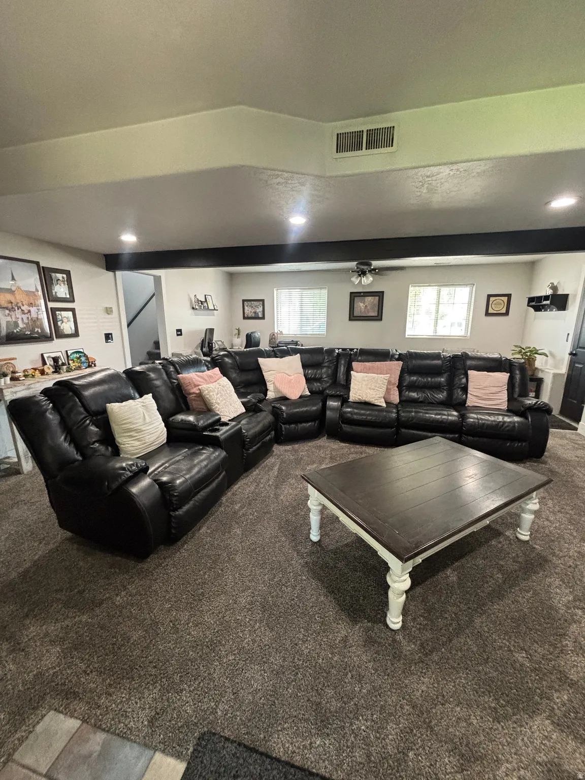 Spacious living area featuring neutral-toned carpet flooring and recessed lighting