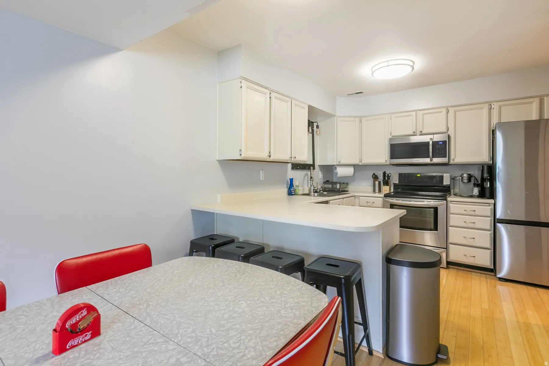 Kitchen featuring white cabinetry, light countertops, and stainless steel appliances