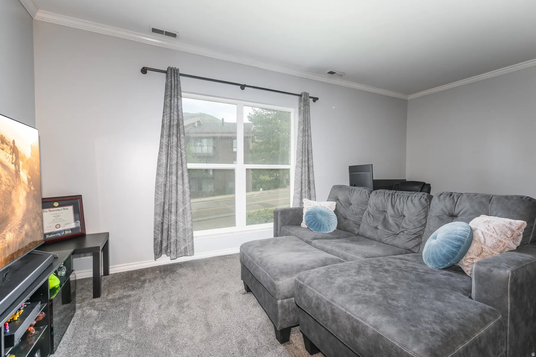 Living area with light gray wall paint and white crown molding