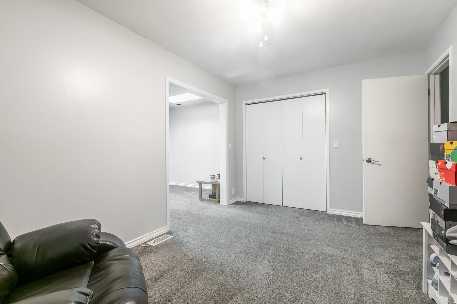 Carpeted room featuring a white bi-fold closet and a white interior door