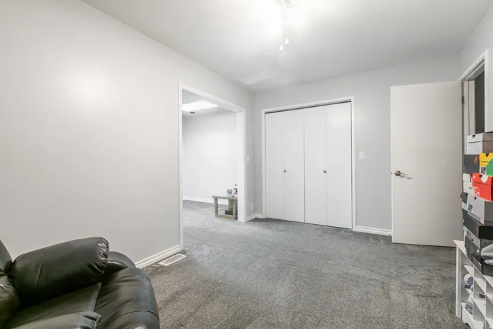Carpeted room featuring a white bi-fold closet and a white interior door