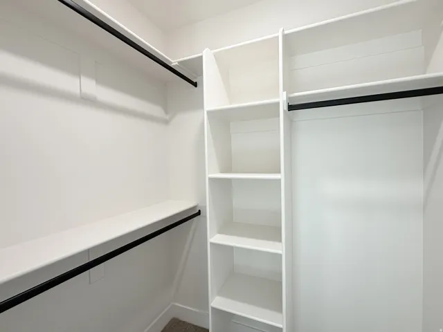 Built-in shelving, multiple hanging rods, and an organized closet system