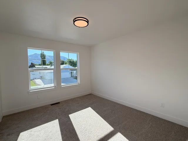 Recessed lighting, neutral wall paint, carpeted flooring, and a double window