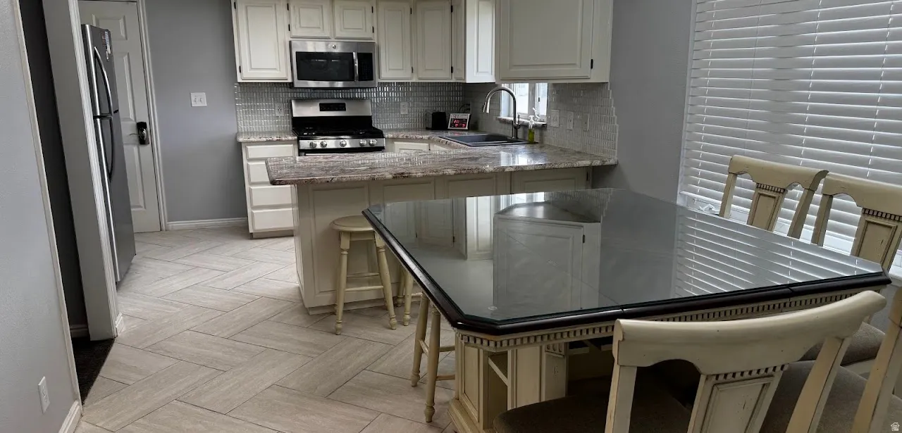 Kitchen is spacious enough for a sizable kitchen table in addition to barstools at the overhanging counter.