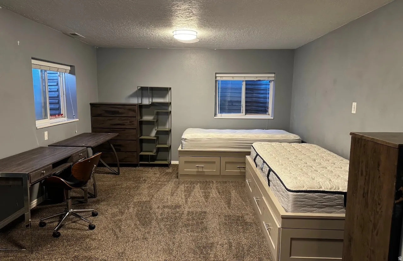 Spacious room with neutral gray walls and textured carpeting