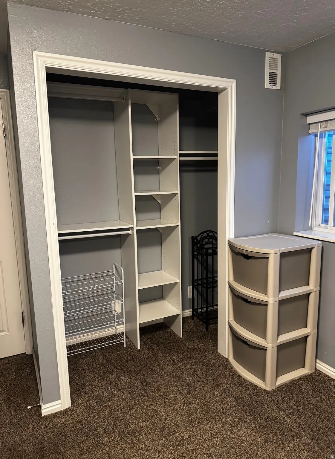 Built-in closet system featuring white shelving and hanging rods
