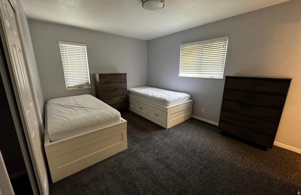 Spacious room featuring gray carpet flooring and neutral wall tones