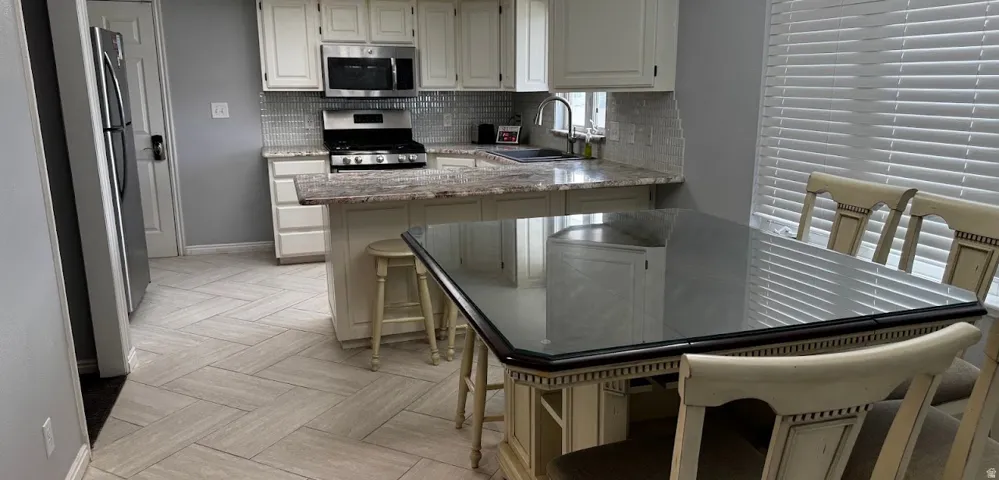 Kitchen is spacious enough for a sizable kitchen table in addition to barstools at the overhanging counter.