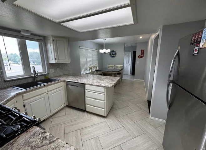 Kitchen includes full size fridge and freezer combo, gas range and oven, dishwasher, microwave, and double sink with disposal.