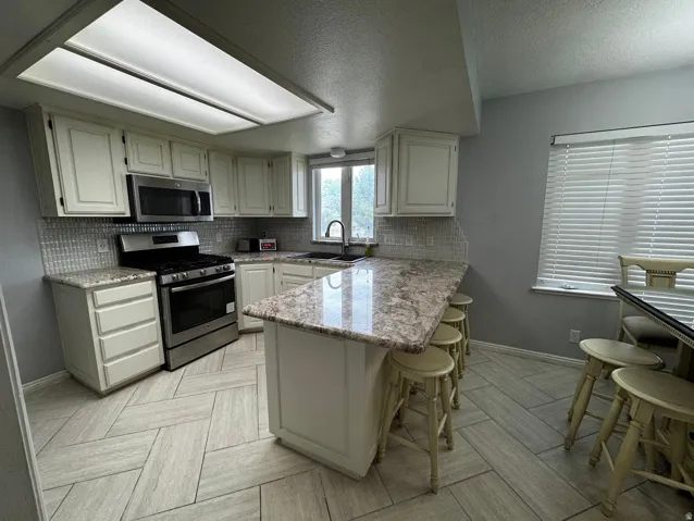 Kitchen's many windows and light colors brings an open and spacious feeling.