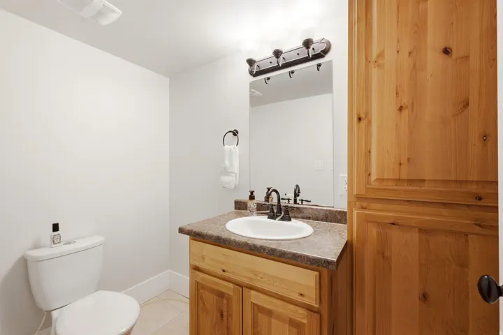 Bathroom featuring a wood-finish vanity with an integrated sink and a speckled countertop