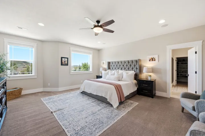 Spacious room featuring carpet flooring, recessed lighting, a ceiling fan, and multiple windows