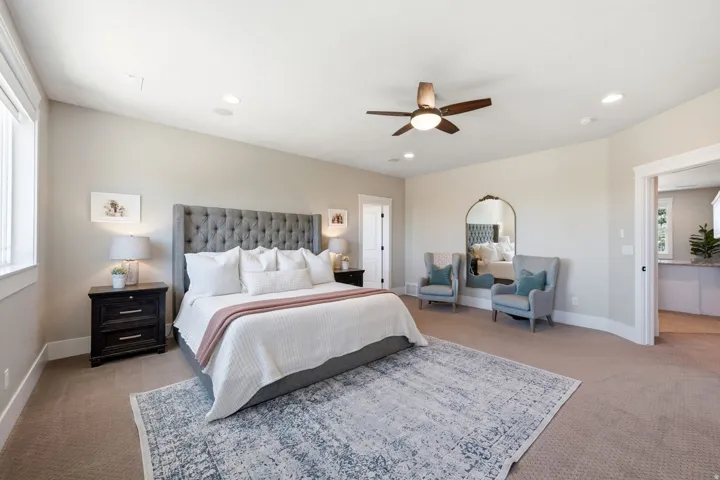 Spacious room featuring neutral carpeting, recessed lighting, a ceiling fan, and ample natural light from a large window
