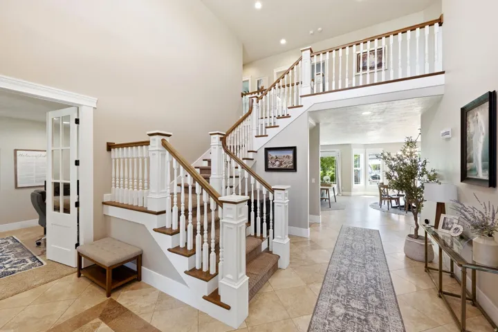 Grand staircase featuring wood treads, white risers, and turned balusters