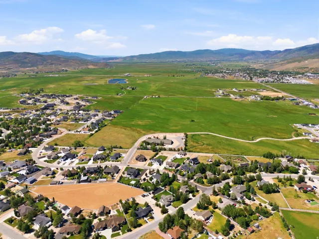 Expansive rural landscape featuring a residential community with abundant green spaces and distant mountains
