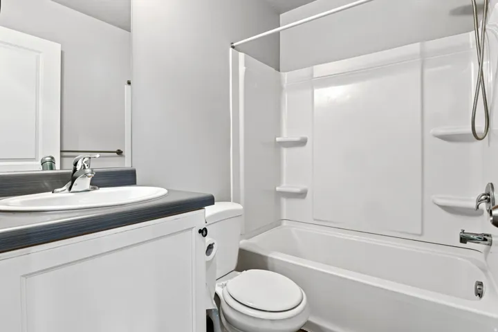 Bathroom featuring a white vanity cabinet with a gray countertop, an undermount sink, and a chrome faucet