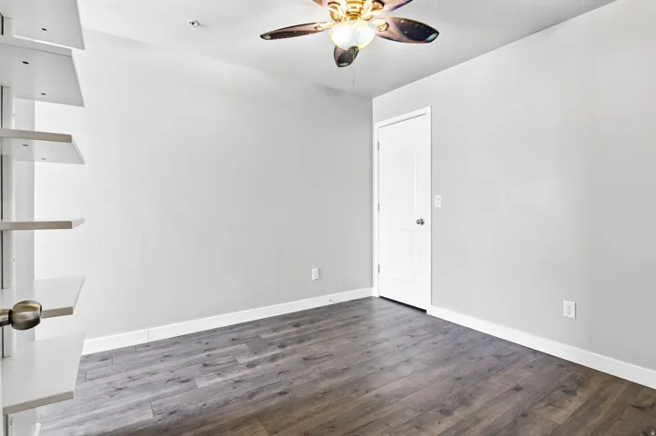 Room featuring wood-finish flooring, light grey wall paint, and white baseboards