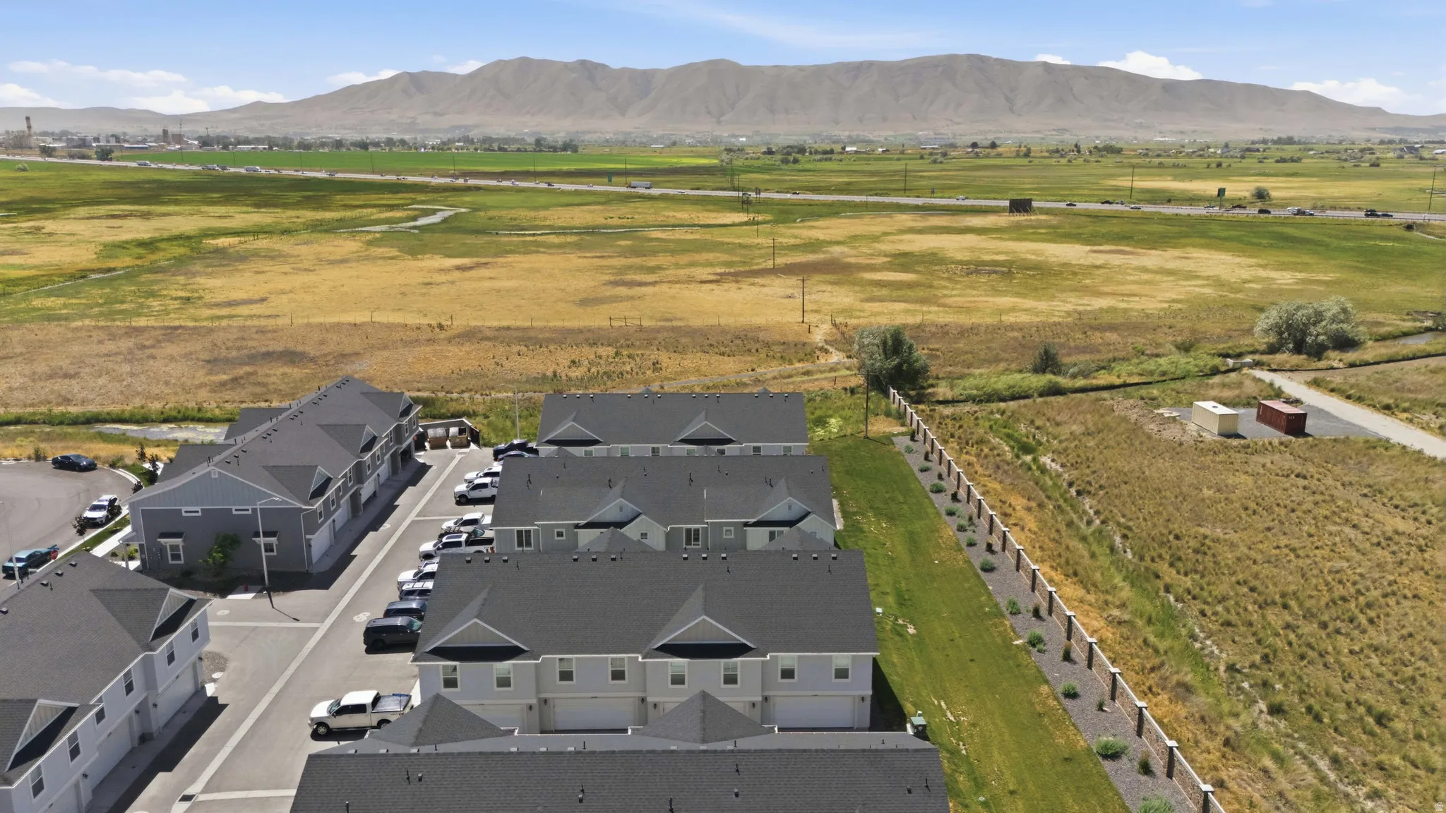 New construction townhomes featuring light gray siding and dark gray shingle roofs