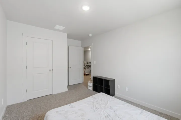 Carpeted room featuring light gray walls, white trim, and a flush-mount ceiling light