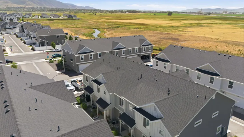 Modern residential development featuring multi-story townhomes with dark shingle roofing and light-toned siding