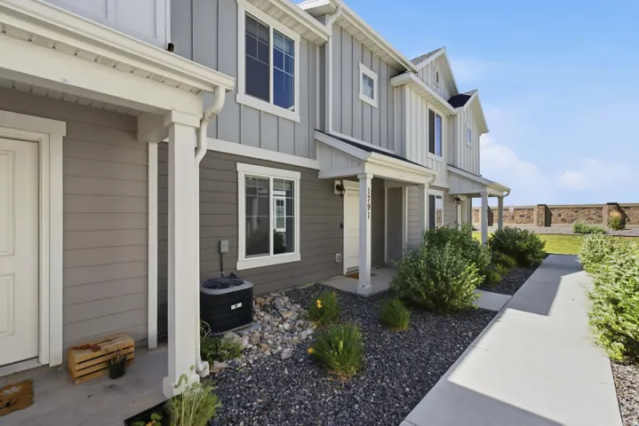 Two-story exterior with vertical and horizontal siding, covered entryways, and white trim accents