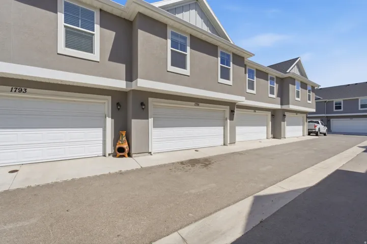 Stucco exterior featuring white trim and multiple windows with blinds