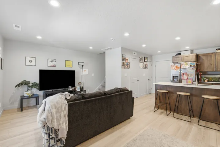Open-concept living space featuring light wood-finish flooring, recessed ceiling lighting, and light gray wall paint