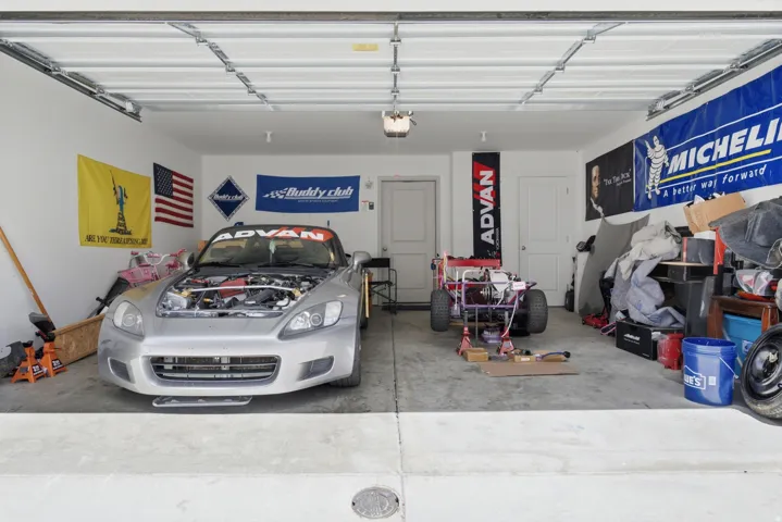 Two-car garage featuring a concrete floor, white walls, and two interior doors