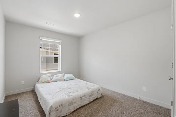 Neutral-toned room featuring a single window, recessed ceiling lighting, light gray painted walls, white baseboards, and carpet flooring